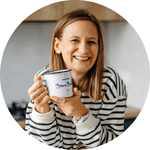 Nathalie Majcher tient une tasse Dr BonneBouffe dans sa cuisine.